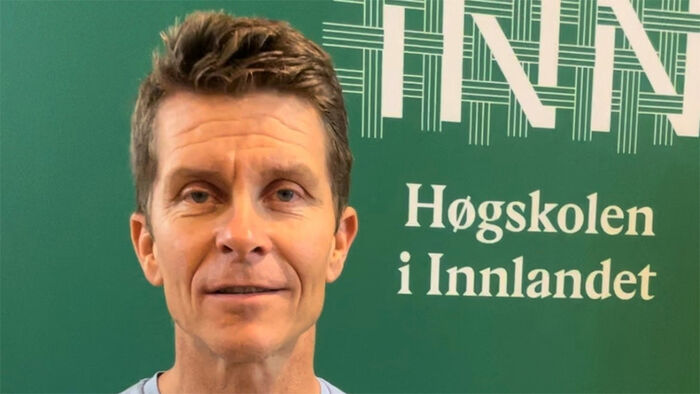 , prater med grønn Høgskolen i Innlandet logo i bakgrunnen