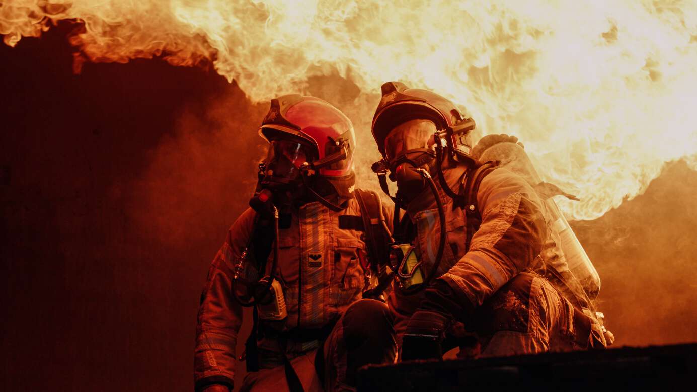 To uniformerte brannmenn i et flammehav