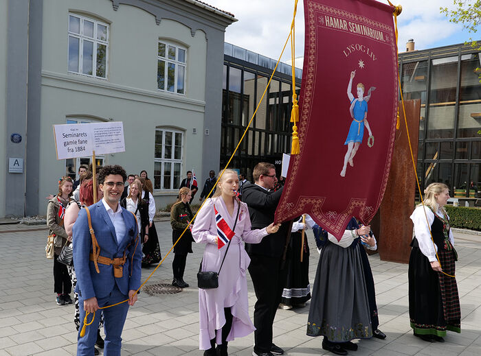 Bildet viser studenter utenfor høgskolen som gjør seg klare til å gå i skoletoget.