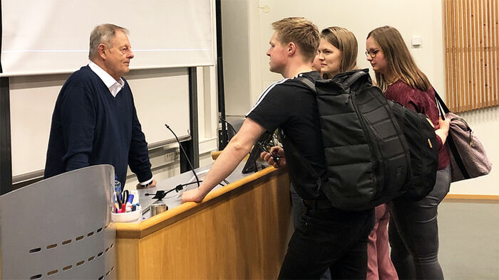 Biletet visar studentar som diksuterer med professor Jim Cummins etter den opne forelesinga.