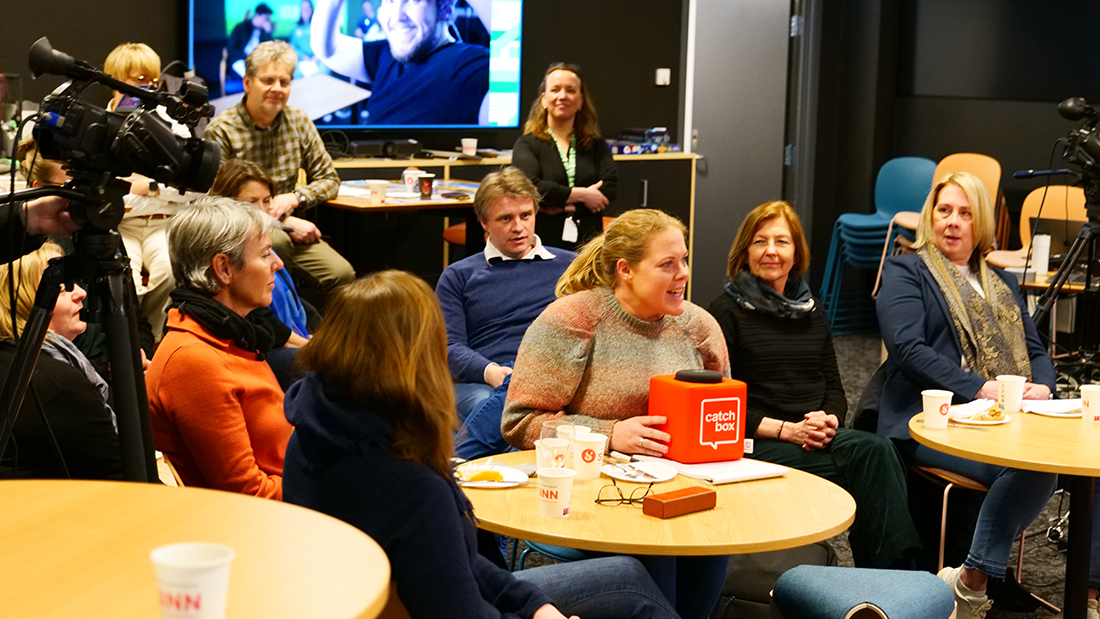 En rekke mennesker som følger med på frokostmøte. 