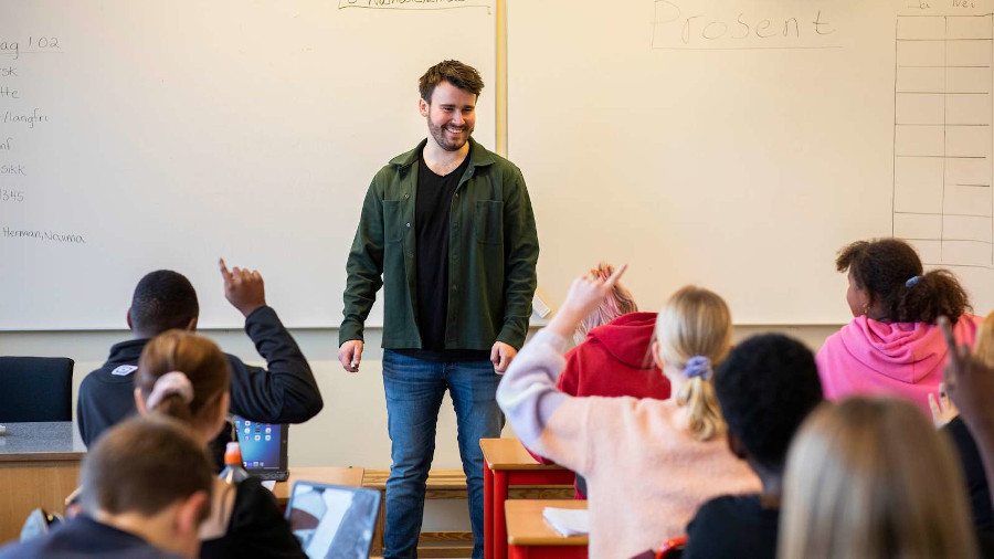 En lærer står foran elever i et klasserom
