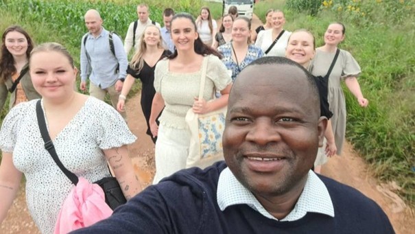 En mann fra Zambia tar en selfie med mange norske lærerstudenter