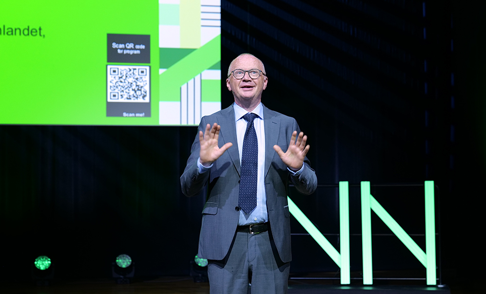 Bilde av konfransier Lars Myhr på scenen, vendt mot publikum.