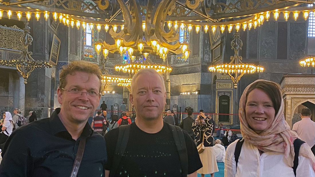 Portrettbilde av tre lærere som står inne i Hagia Sofia. 