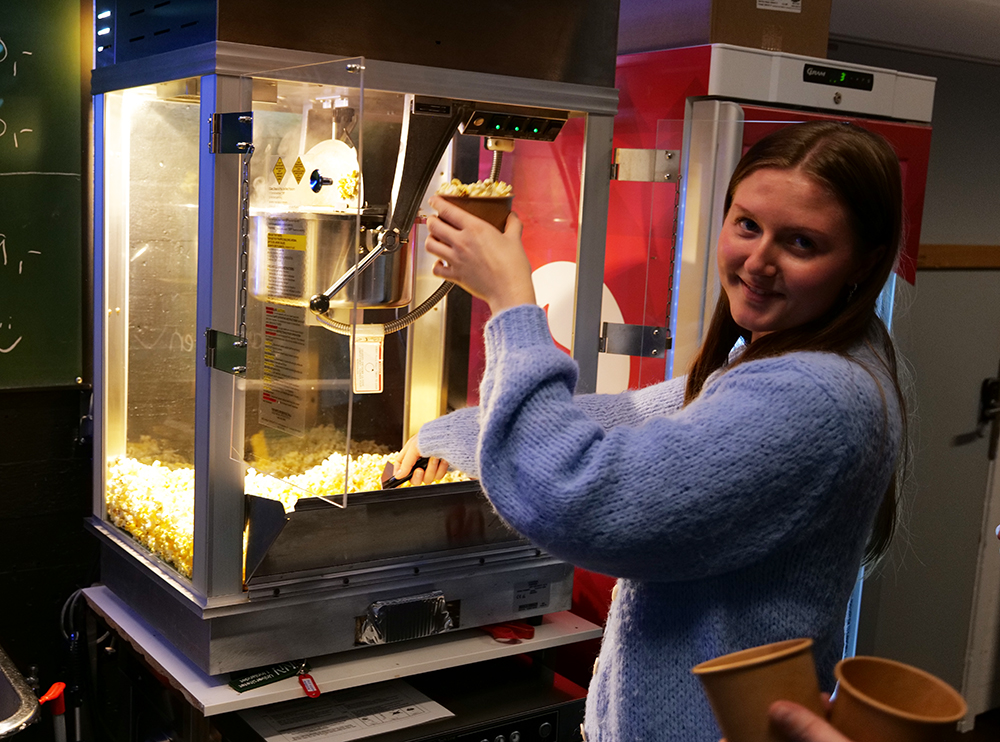 Student Alia Bosnes viser hvordan man bruker popcorn-maskinen, som var en gave fra Fakultet for lærerutdanning og pedagogikk.