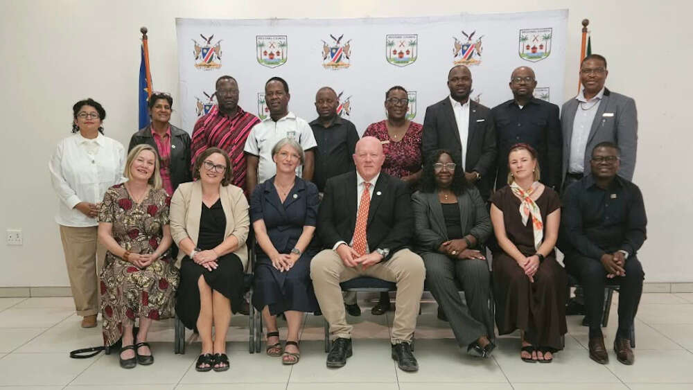 16 sittende personer i to rekker. Bildet viser delegasjonene fra Universiy of Namibia og Universitetet i Innlandet under besøket i Namibia..