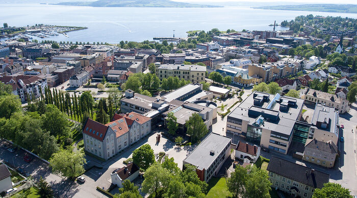 Dronebilde av hele studiested Hamar med Hamar sentrum og Mjøsa i bakgrunnen.