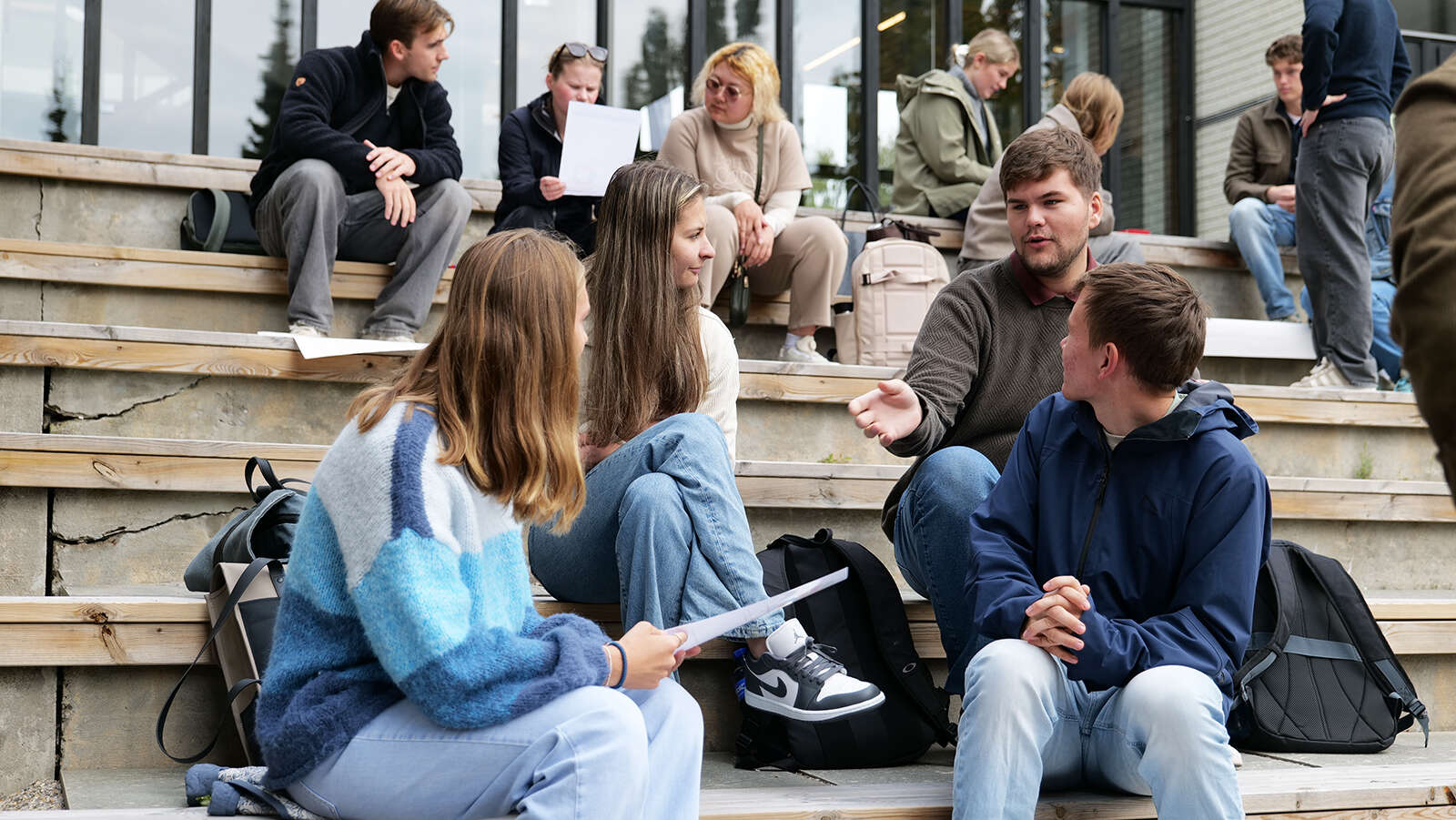 Bilde av fire lærerstudenter som sitter ute på studiested Hamar og diskuterer.