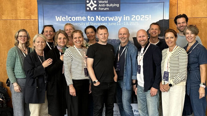 Gruppebilde av SELL-ansatte foran konferanseskilt