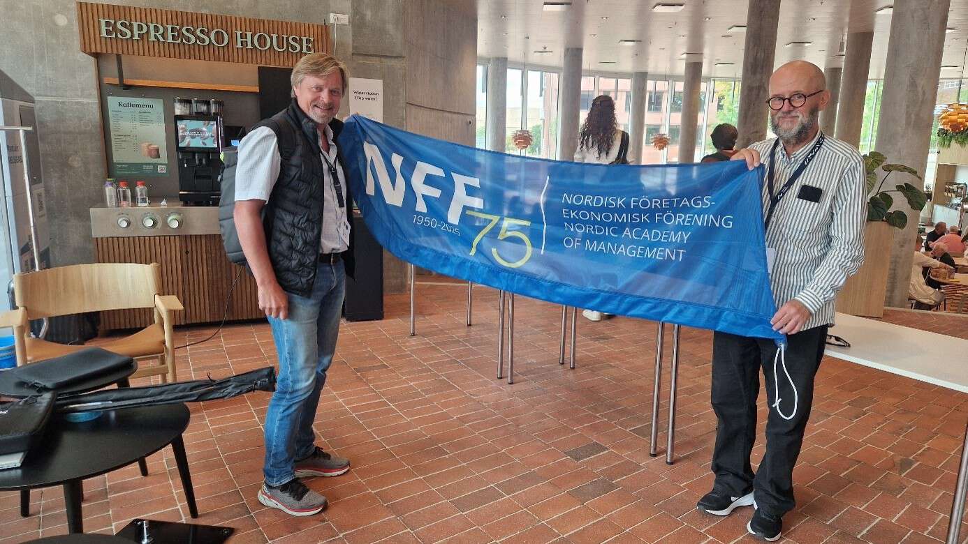 to personer holder banner for NFF mellom seg