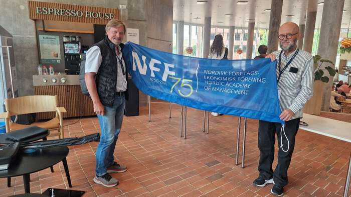 to personer holder banner for NFF mellom seg