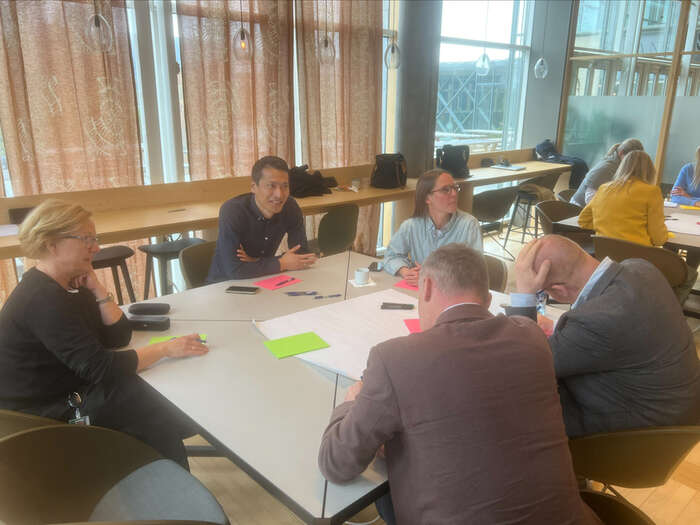 medlemmer av fakultetsrådet diskuterer rundt et bord