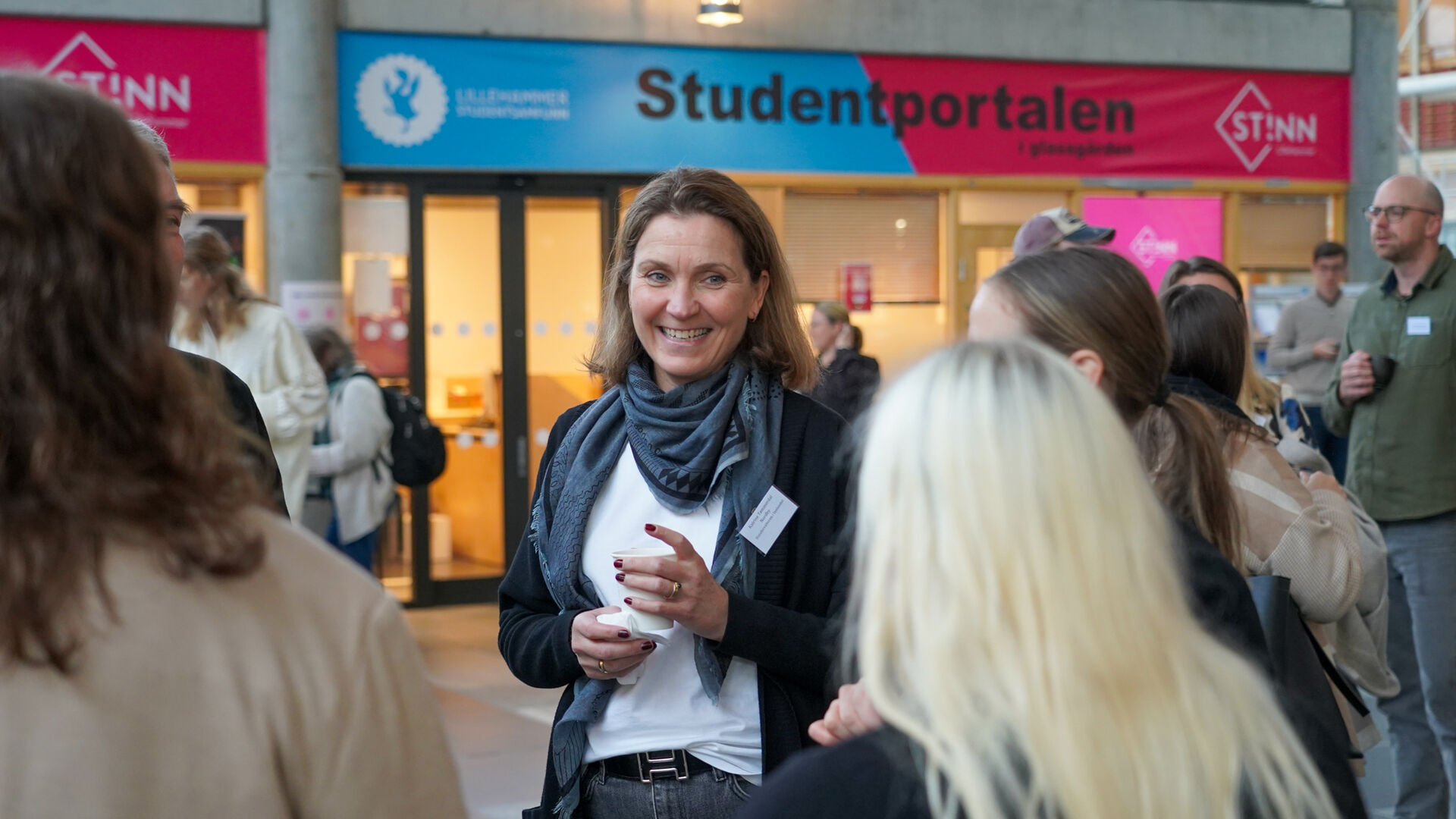 dame står i en gjeng og snakker