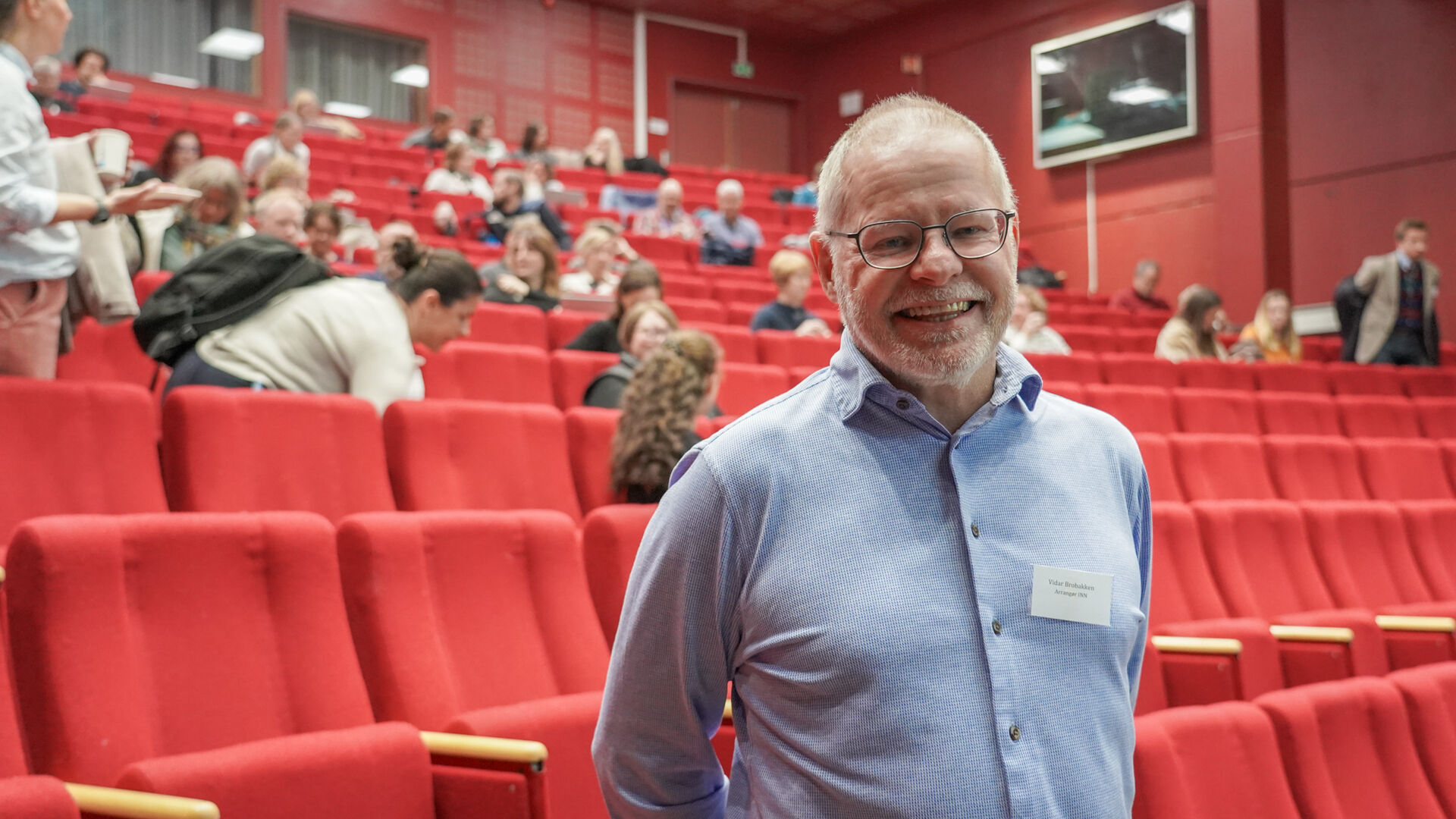 mann står foran folk i et auditorium