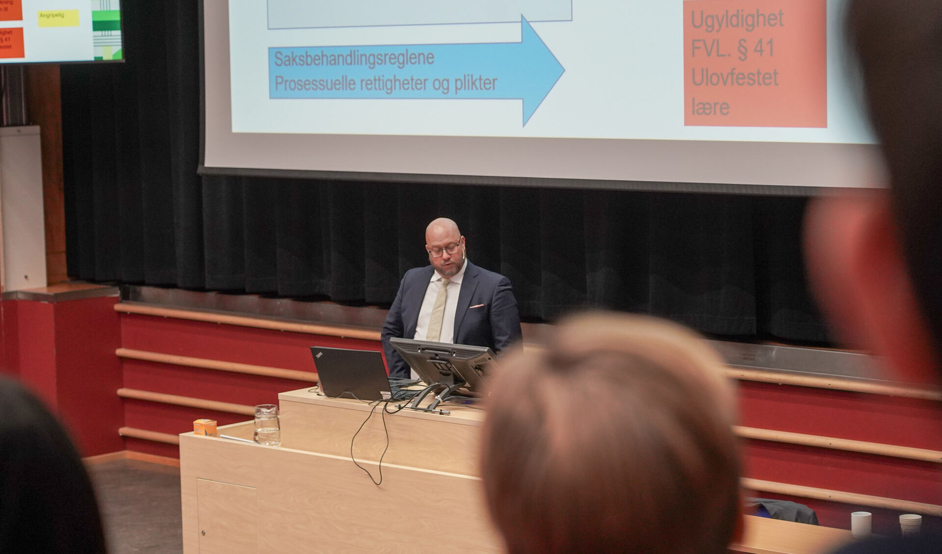 Mann foran et stort lerret i et auditorium
