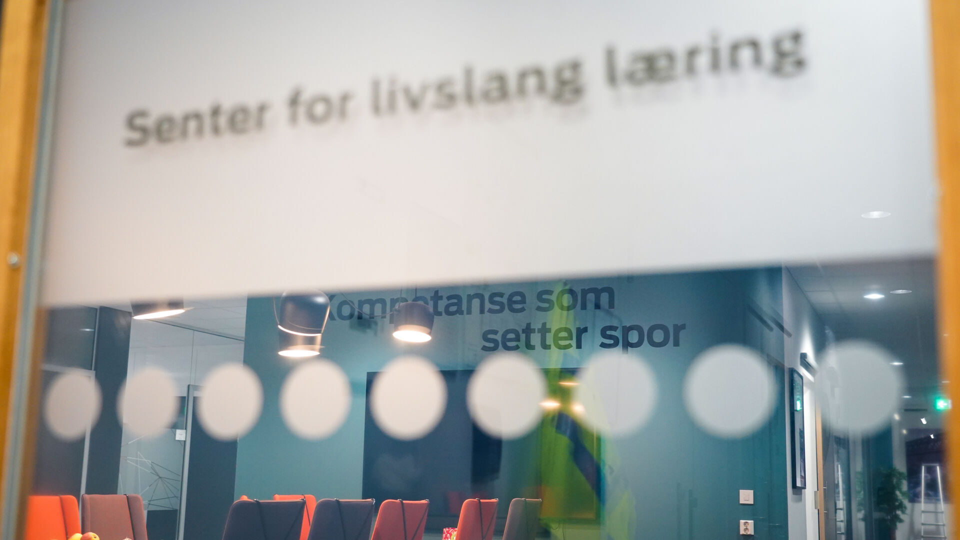Bilde av en logo på en vegg som sier KOmpetanse som setter spor