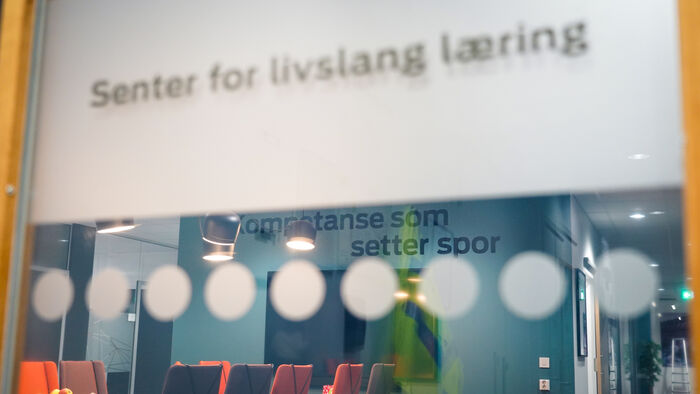 Bilde av en logo på en vegg som sier KOmpetanse som setter spor