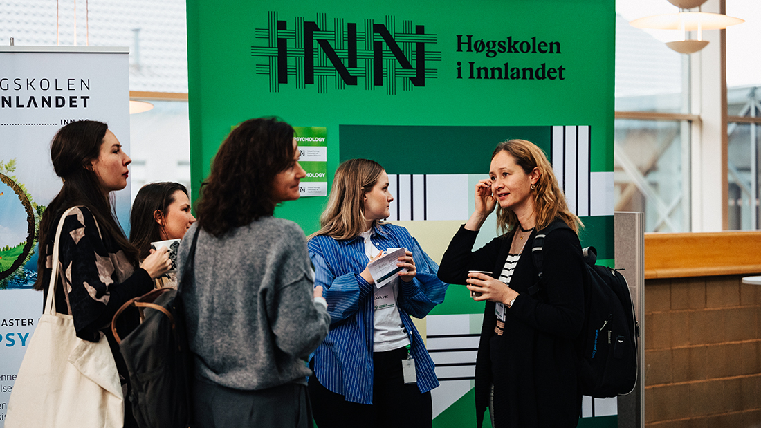 Studenter som står i en halvsirkel og prater sammen. 