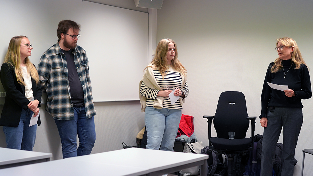 Studenter som holder en presentasjon for en rekke mennesker. 