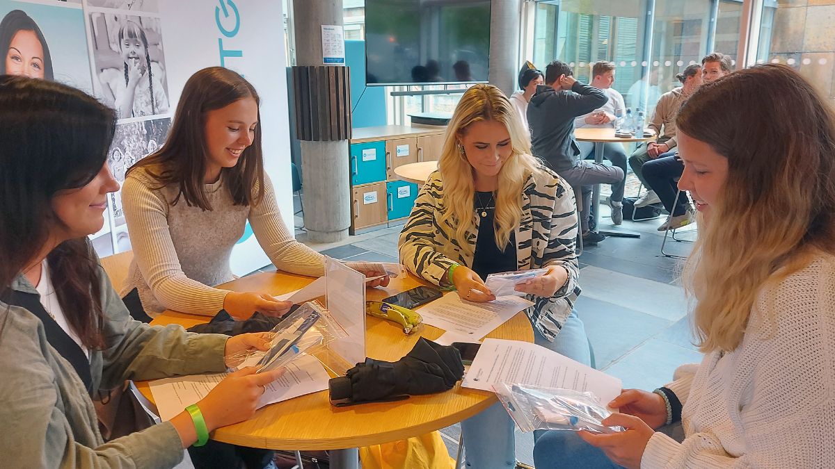 Studenter sittende rundt et bord med testutstyr. 