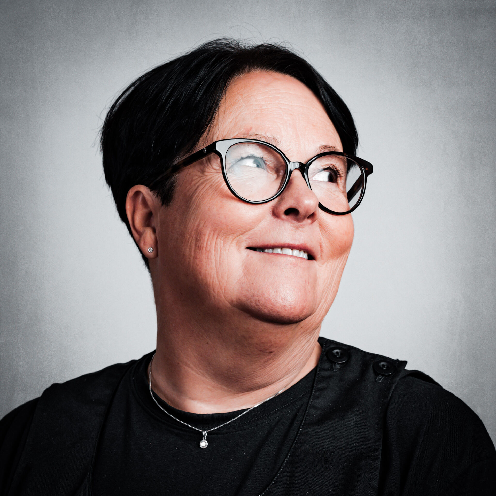 Portrettbilde av Tove Svisdal som smiler og ser skrått oppover