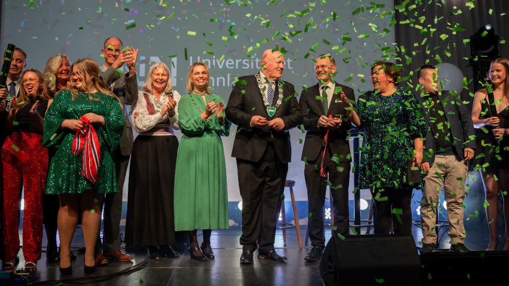 En statsråd, en rektor, fem ordførere og en gruppe studenter på scena under festen