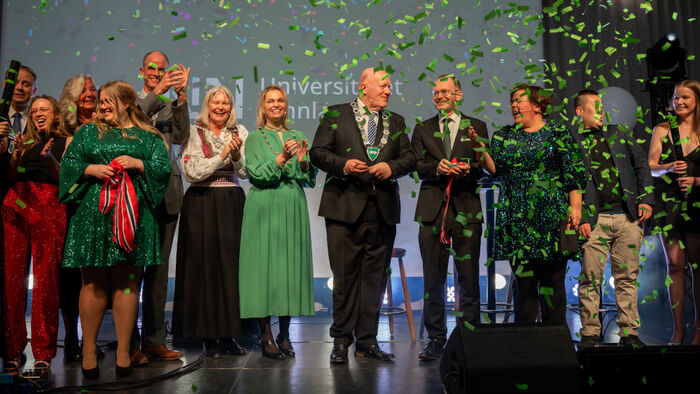 En statsråd, en rektor, fem ordførere og en gruppe studenter på scena under festen