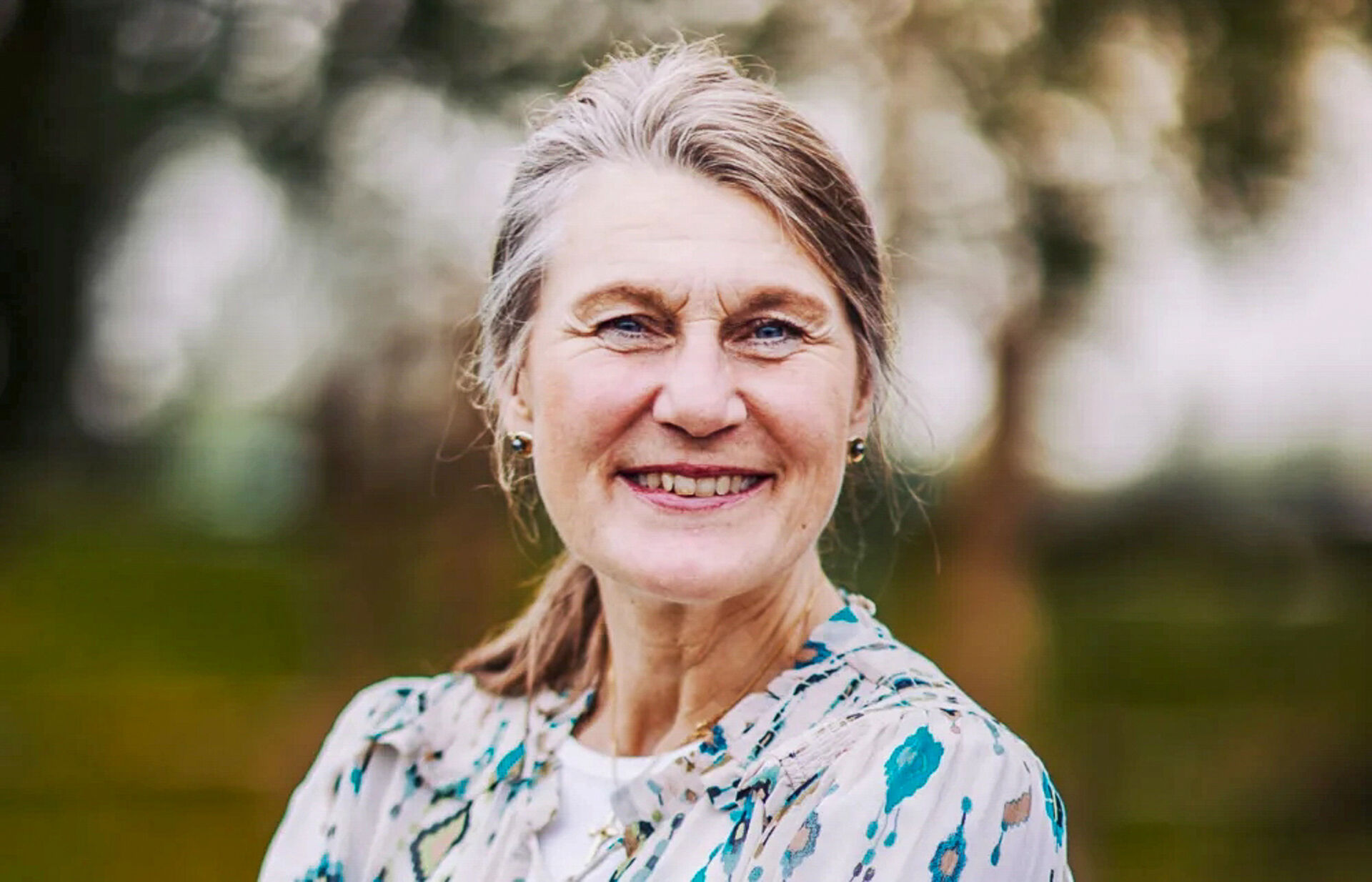 Portrettbidle av eldre dame mot uskarp bakgrunn