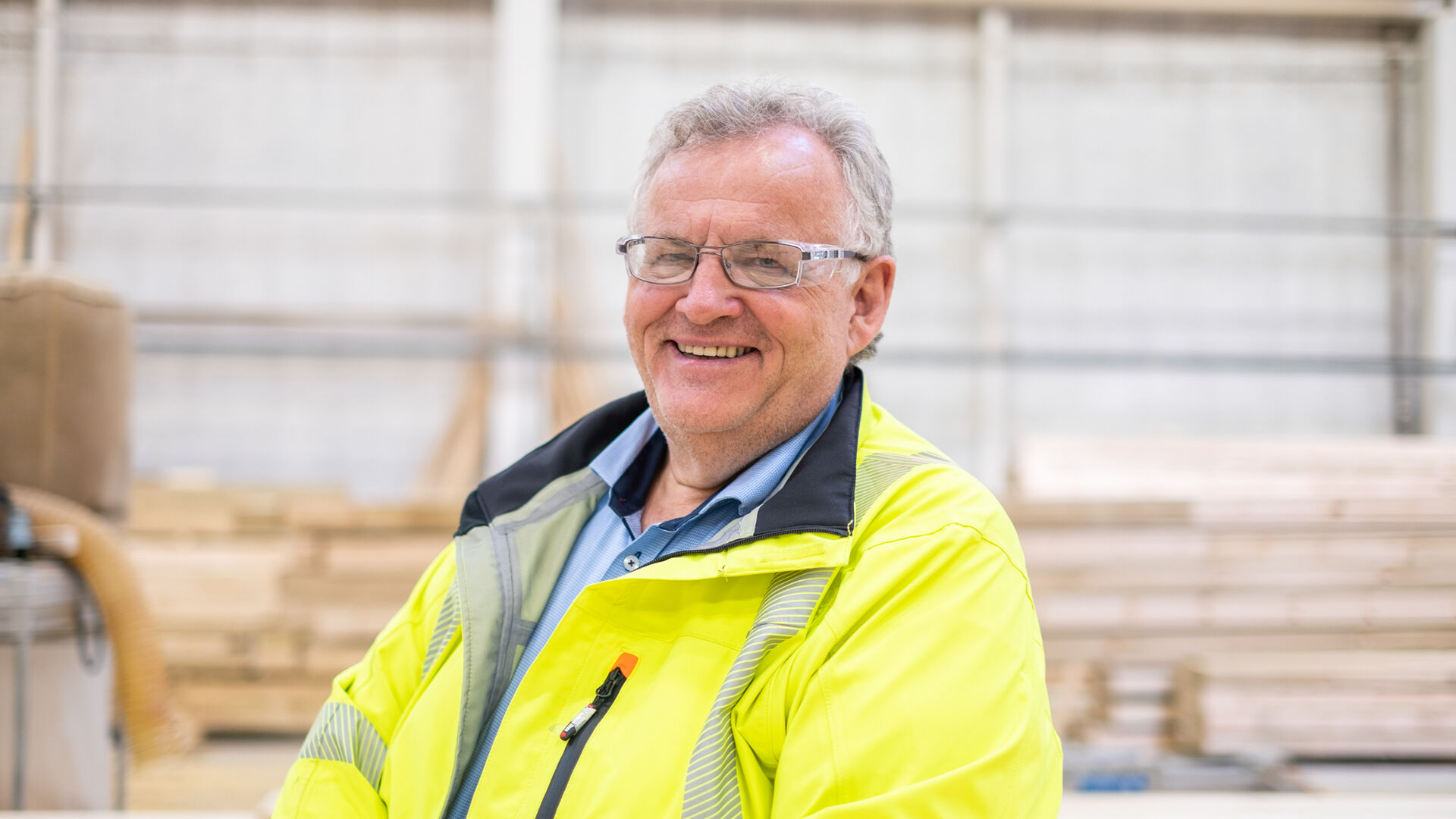 Morten Kristiansen i gul refleksjakke inne på området til Moelven industrier