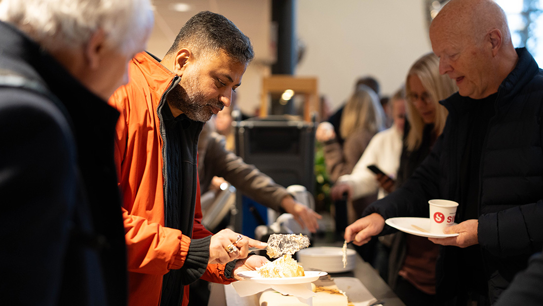 Ansatte og studenter som spiser kaker. 