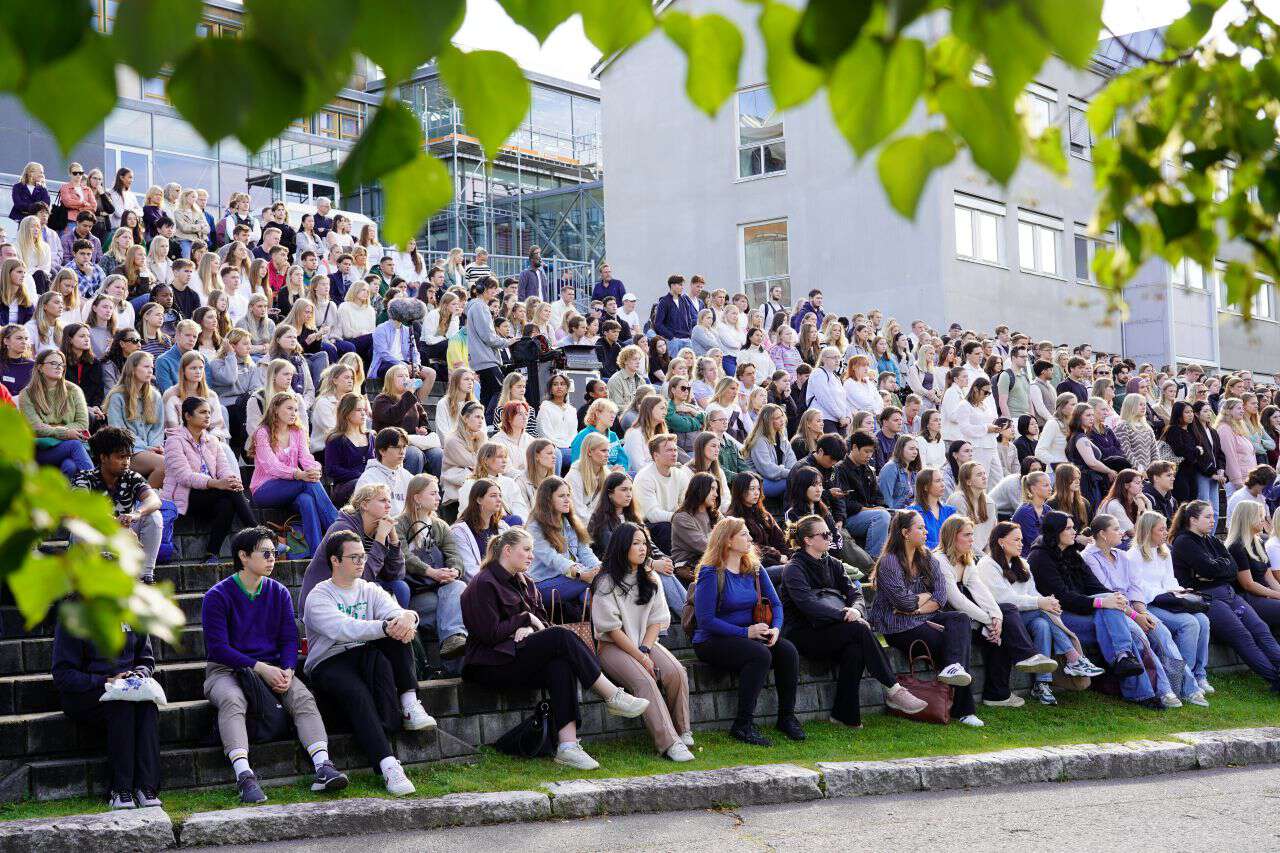 Mange nye studenter sitter i amfiet utenfor campus på Storhove.