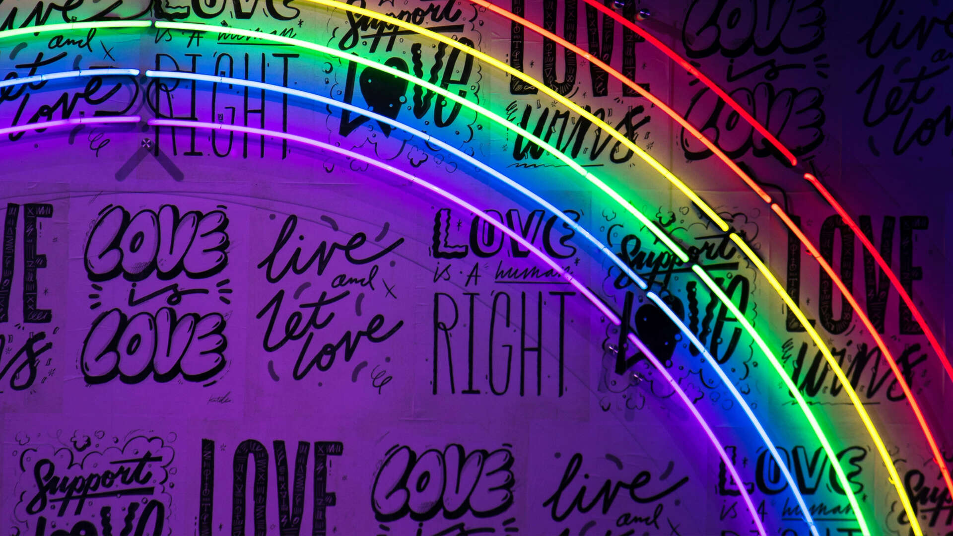 neonlys regnbue med tekst love love på en vegg