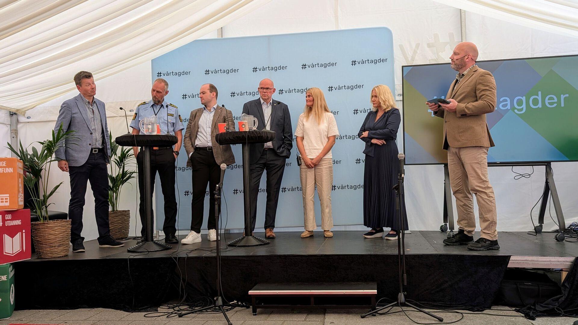 Sju representanter for de ulike samarbeidspartnerne i prosjektet på rekke og rad på en scene.