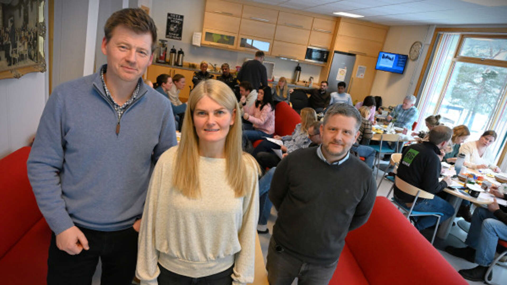 Tre stykker står inne i et klasserom