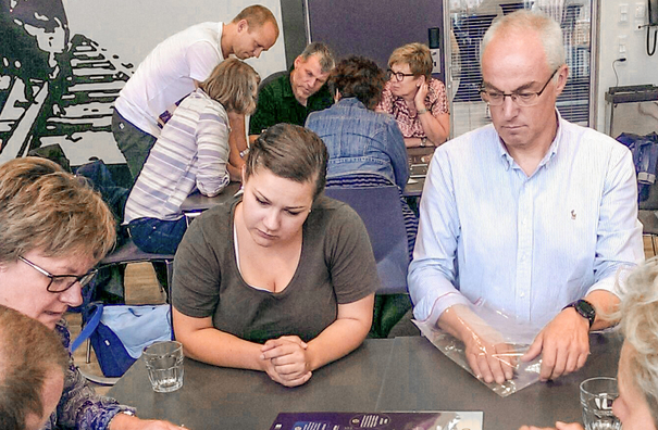 Studenter som sitter rundt et brett spill ved et bord.