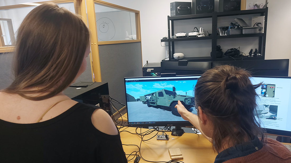 Silje Kroken og Ole Midthun ser på en PC-skjerm som har et bilde av et militært kjøretøy. 
