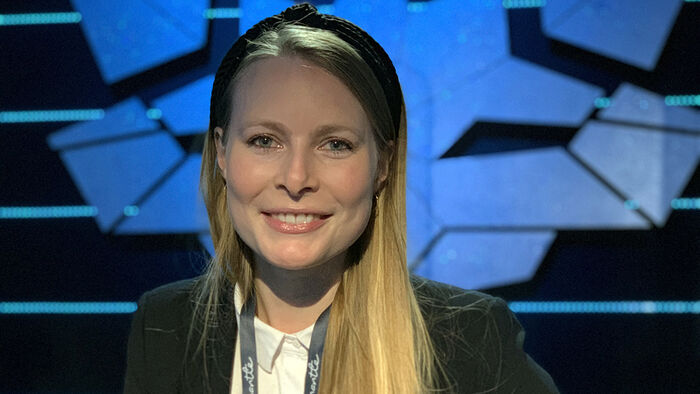 Portrettfoto av Trine Slaatsveen i et mørkt TV-studio. 