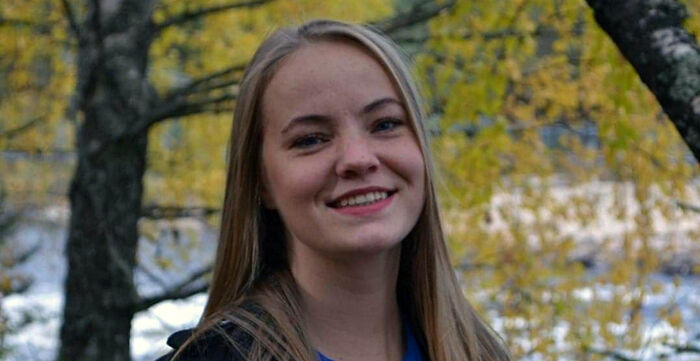 Portrettfoto av kvinnelig student foran et tre. 
