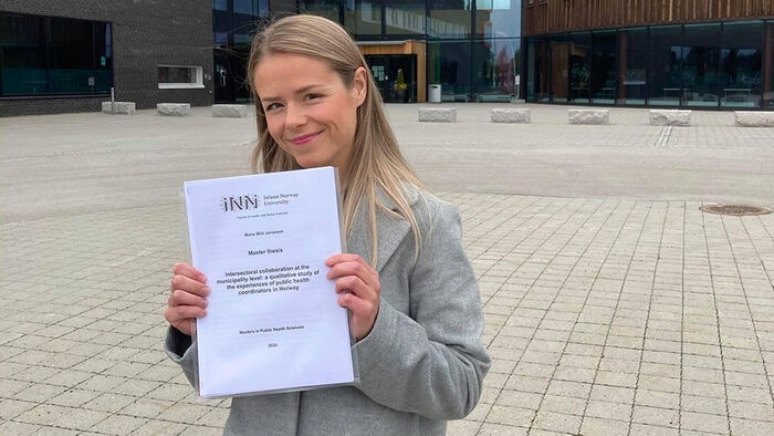 Kvinnelig student med vitnemålet sitt utenfor Terningen Arena. 