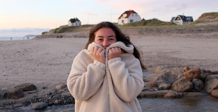 Kvinnelig student på en strand. 