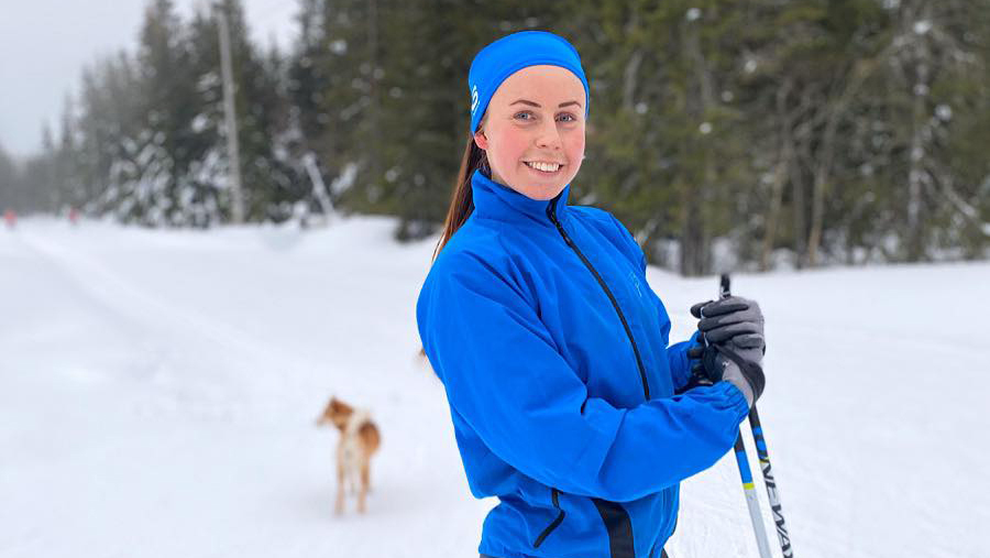 Kvinne på skitur med en hund. 