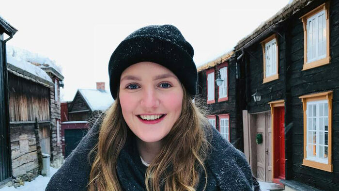 Smilende jenten utendørs på vinterstid. 