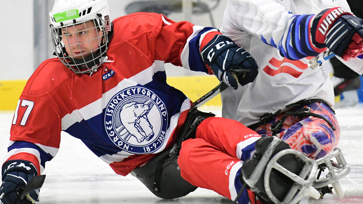 Mann som spiller kjelkehockey. 
