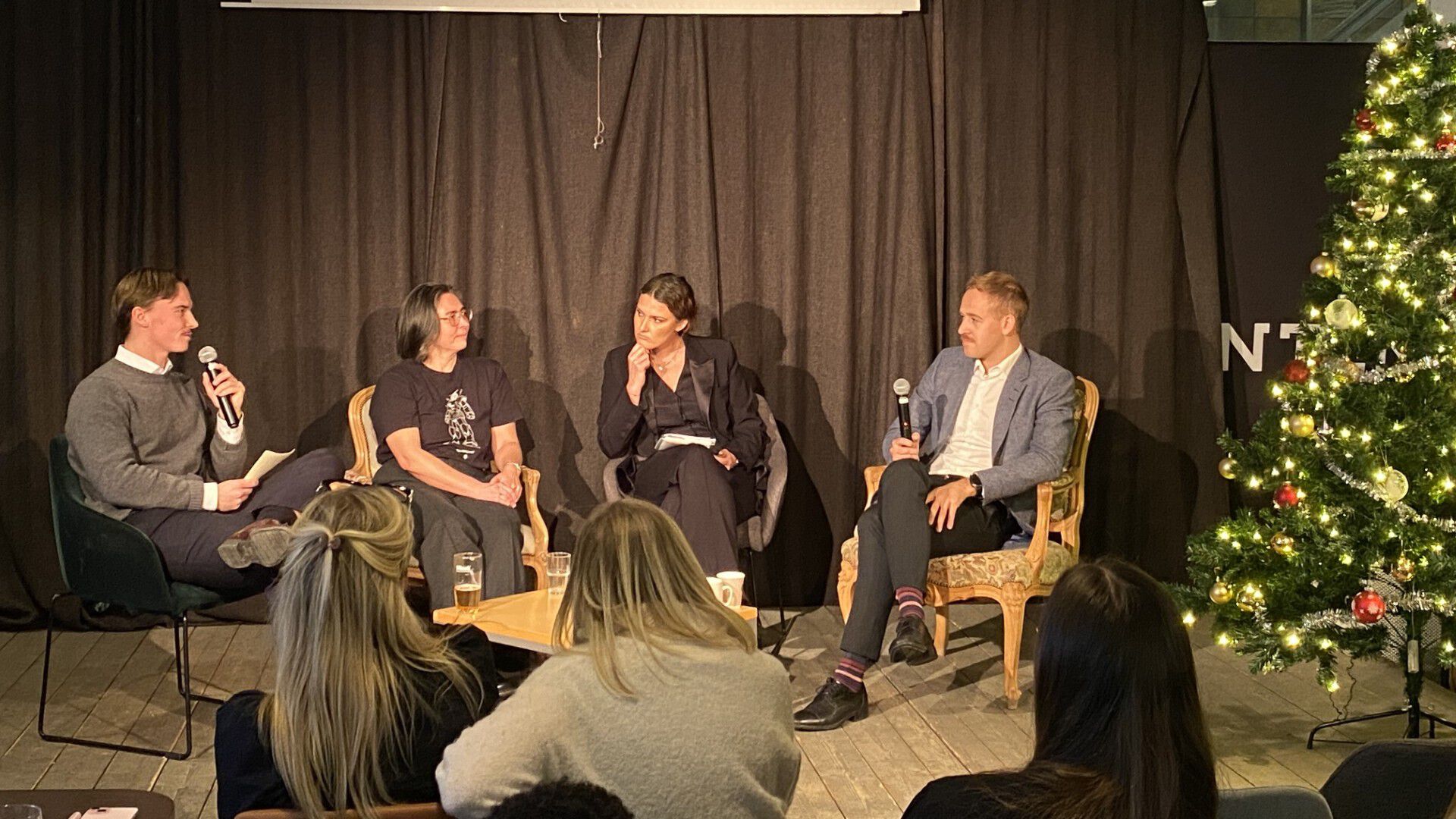 bilde fra paneldebatt med fire deltakere