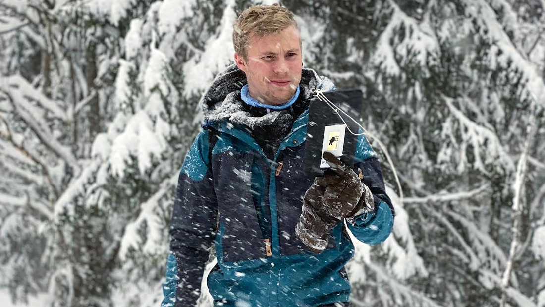 Portrettbilde av Markus Stock som er ute i skogen på vinterstid. 