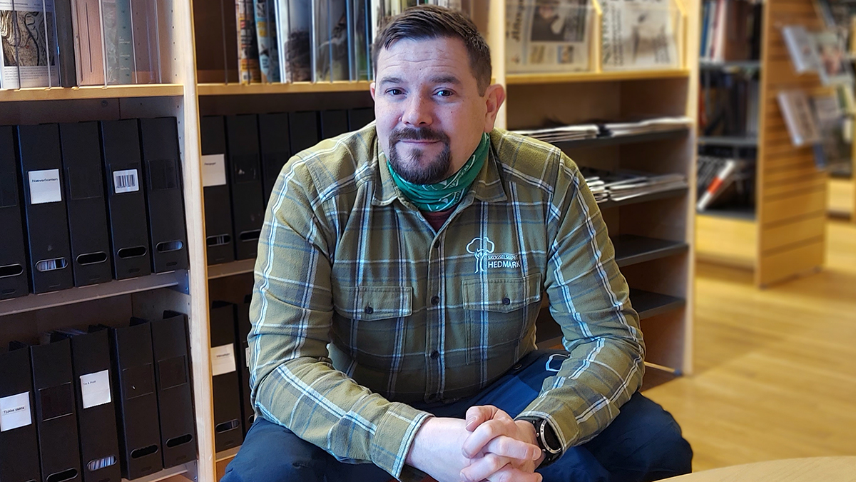 Mann som sitter på en stol i et bibliotek. 