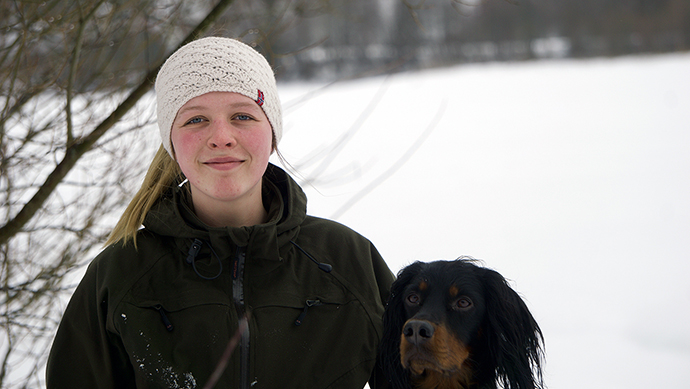 Kvinnelig student med en hund. 