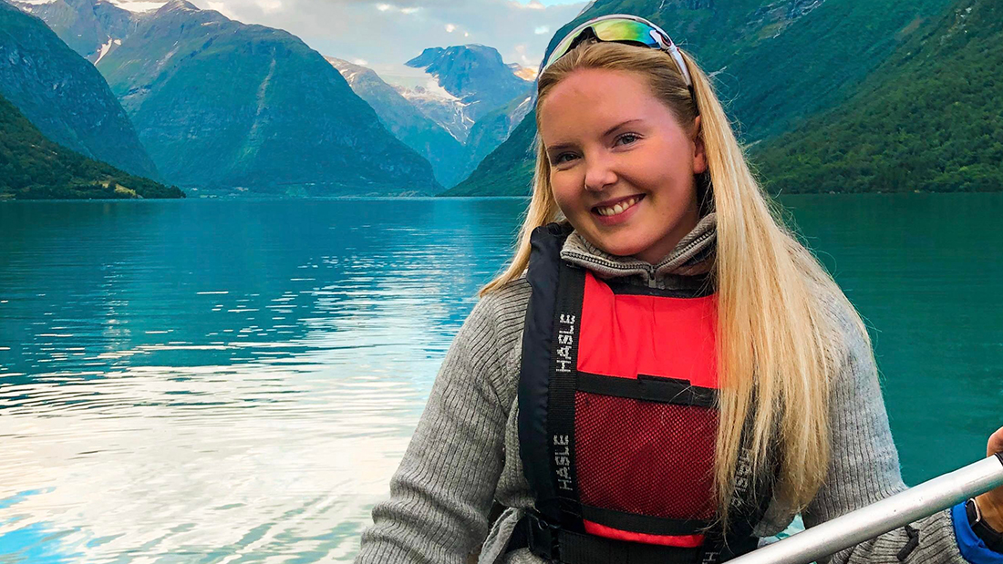 Kvinnelig student i kano på en innsjø. 