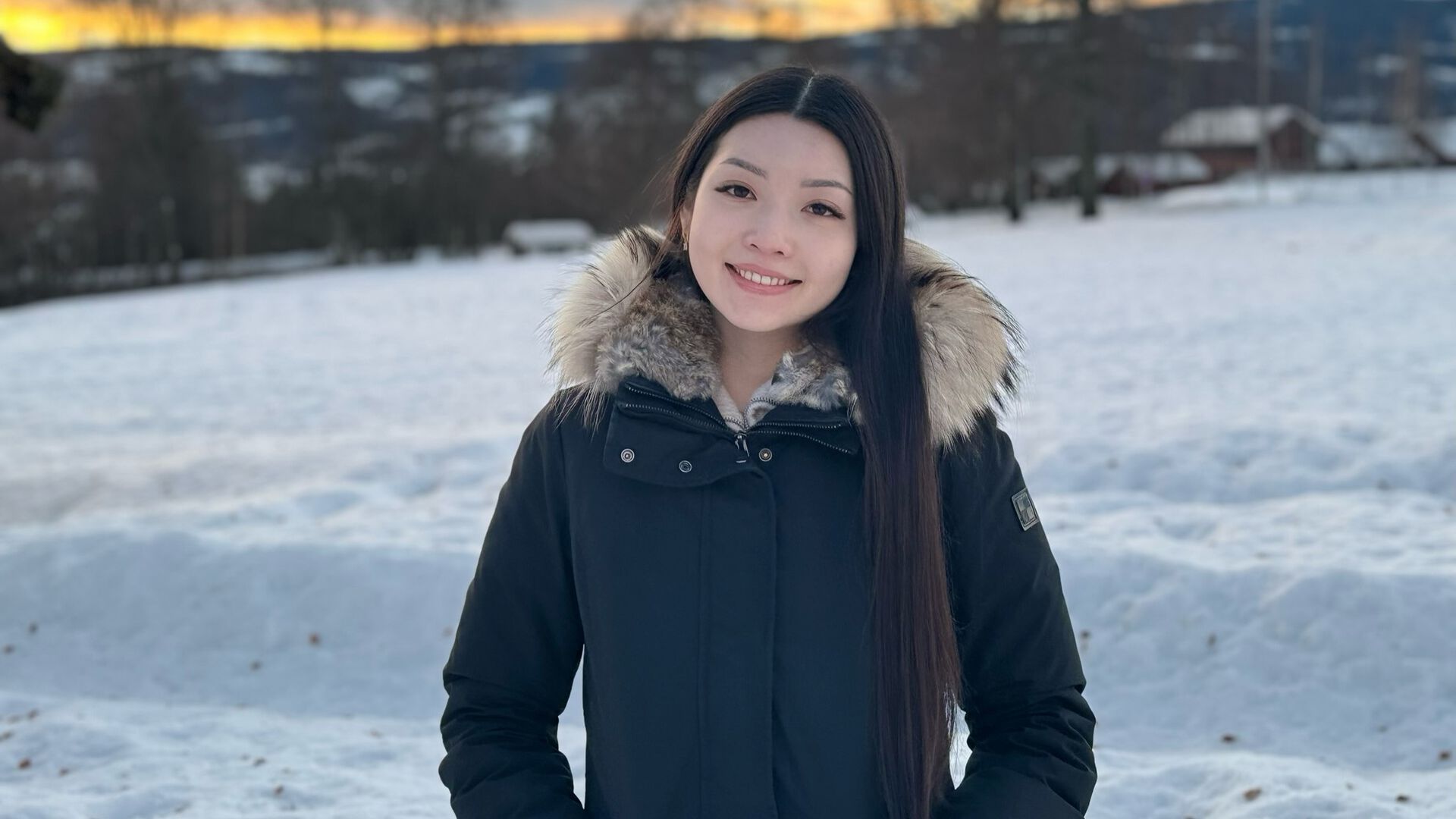 Bilde av masterstudent Kantita Iversen, hun er utendørs med snø i bakgrunnen.
